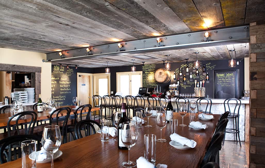 Open table seating with wine glasses and table settings in front of the Bin 22 bar in Jackson, Wyoming.